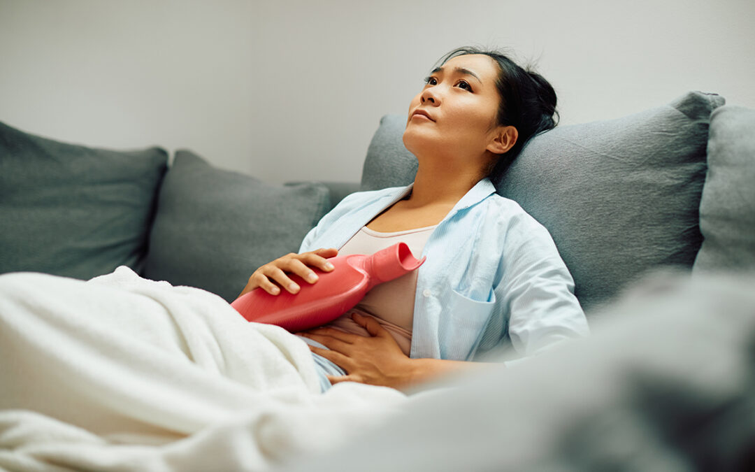 Women with Endometriosis holding a hot water bottle to her tummy